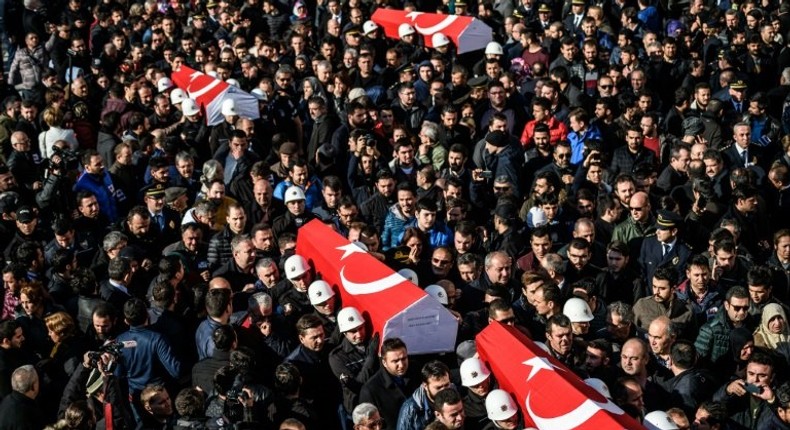 Turkish police officers carry the coffins of comrades killed in bomb attacks during a funeral cerenomy at Istanbul's police headquarters on December 11, 2016