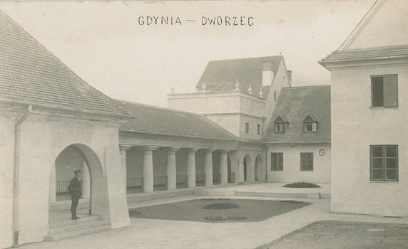Dziedziniec wewnątrz zabudowań Dworca Kolejowego w Gdyni w 1926 r., który był uznany za ukoronowanie i ostatni wielki przejaw stylu dworkowego w polskiej architekturze kolejowej, a przejawiał już cechy nowego prądu modernizmu. Dworzec ten otwarto 15 lipca 1926 r.