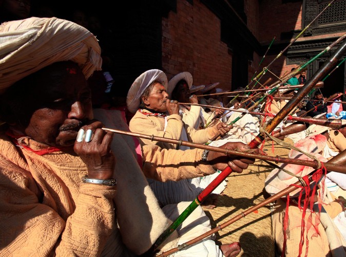 Nepalscy duchowni w tradycjnych strojach dmą w trąby w czasie obchodów święta Seekali w Katmandu