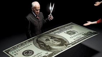 Businessman holding scissors and reaching hands around one hundred dollar bill
