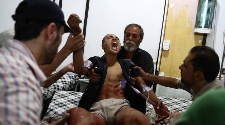 Sebesült szíriai férfit elsősegélyben részesítenek egy tábori kórházban - Fotó: AFP