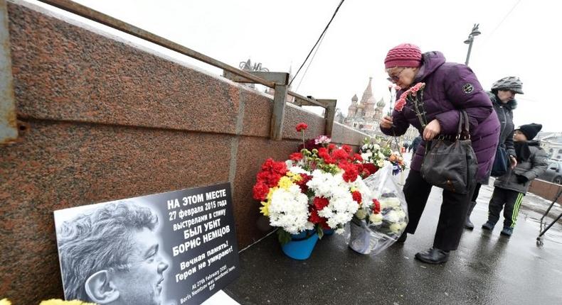 A woman lays flowers in Moscow at the site where Russian opposition leader Boris Nemtsov was shot dead to mark the second anniversary of his assassination in February 2017