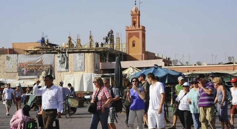 Tourists walk around the Argana restaurant (background) at Marrakesh?s famous Jemma el-Fnaa square, June 22, 2012. REUTERS/Abderrahmane Mokhtari