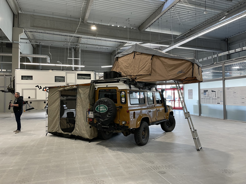 Land Rover Defender z namiotem i przedsionkiem.