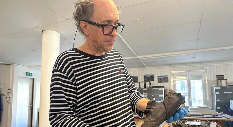Pierre-Yves Nicod holds the mystery traveler's 400-year-old shoe.Morgan McFall-Johnsen