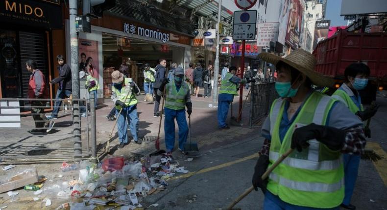 Workers clear debris on a street following the Mongkok riots of February 2016