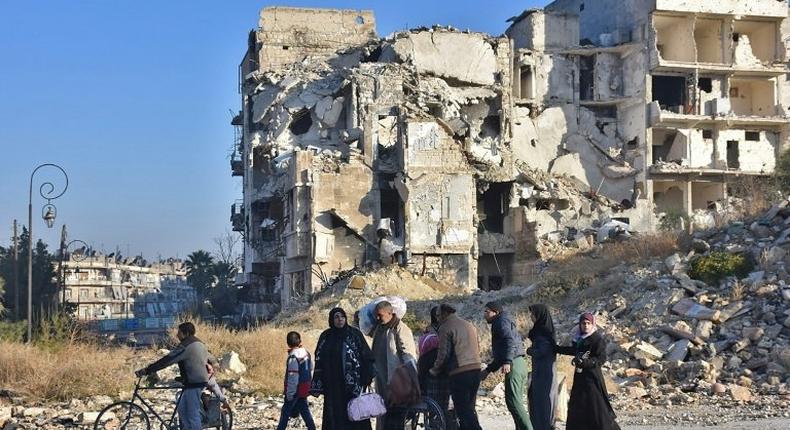 Syrian residents fleeing the violence in the eastern rebel-held parts of Aleppo evacuate from their neighbourhoods through the Bab al-Hadid district after it was seized by the government forces, on December 7, 2016