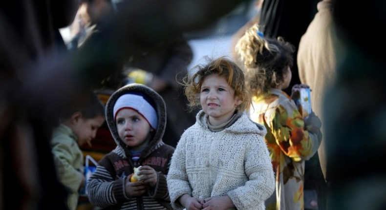 Displaced Iraqis who fled Mosul receive food and drink in Bartalla, east of Mosul