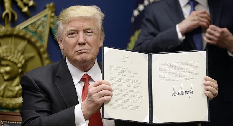 President Donald Trump signs the executive order halting immigrants from some Muslim-majority countries from entering the US.