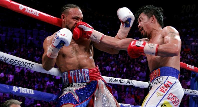 Filipino boxer Manny Pacquiao slams a right to the face of American Keith Thurman