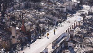 Firefighters walked through destroyed streets to survey the damage.