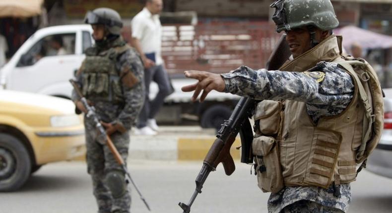 Iraqi security forces patrol a Baghdad street