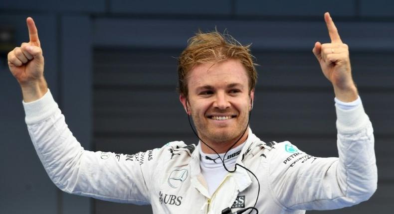 Mercedes AMG Petronas F1 Team's German driver Nico Rosberg stands on his car celebrating after winning the Formula One Japanese Grand Prix race in Suzuka on October 9, 2016