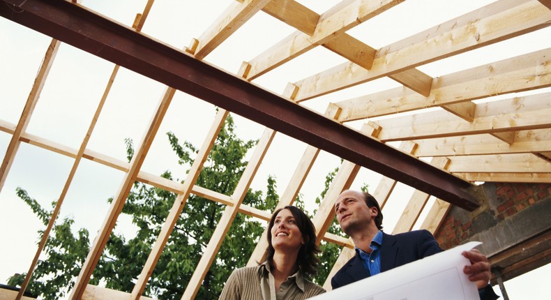 A couple holding the blueprint for a home.Getty Images