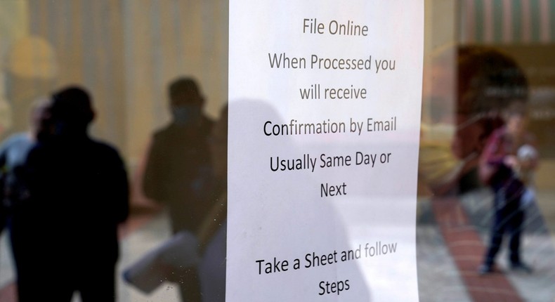 FILE PHOTO: People who lost their jobs are reflected in the door of an Arkansas Workforce Center as they wait in line to file for unemployment following an outbreak of the coronavirus disease (COVID-19), in Fort Smith, Arkansas, U.S. April 6, 2020. REUTERS/Nick Oxford -/File Photo/File Photo