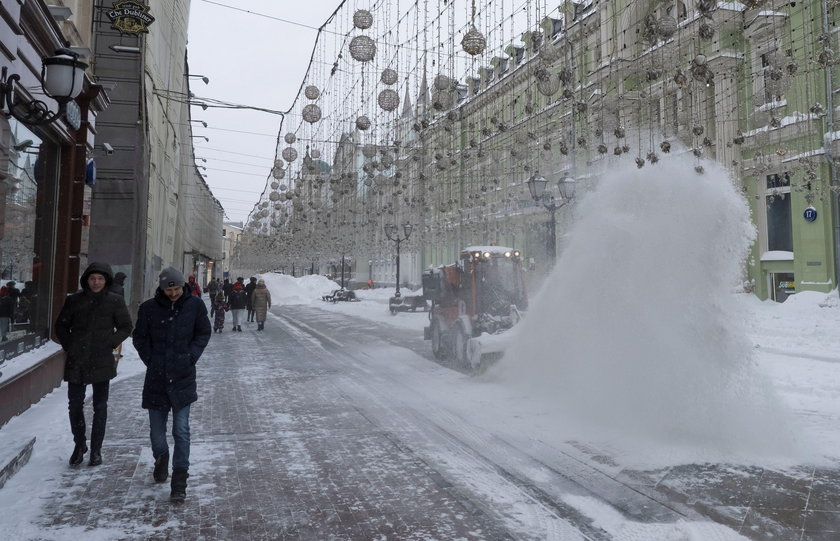 Workers remove snow in a street in Moscow