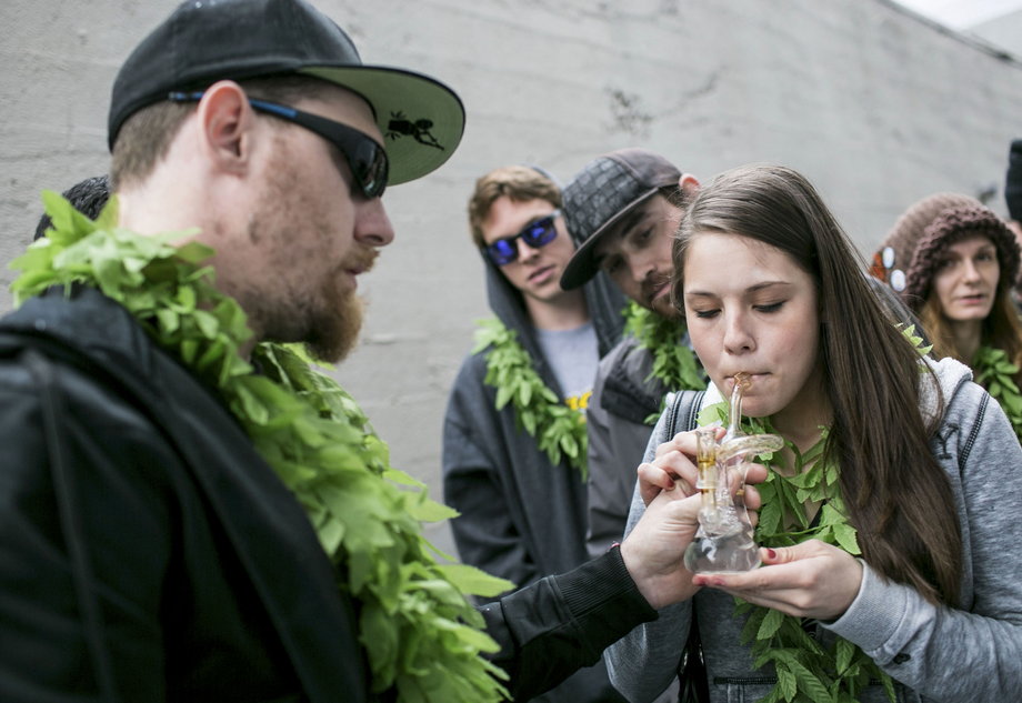 Mary Becker, 21 of Boise, Idaho, inhales hash oil during 420Fest at the Luxe Nightclub in Seattle, Washington.