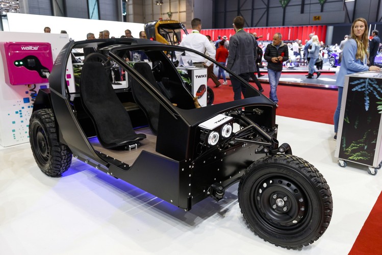 Trójkołowy lekki pojazd elektryczny dla dwóch osób ma oprócz pedału elektrycznego dodatkowo pedały rowerowe. Jeśli chcesz, możesz wesprzeć napęd mocą własnych mięśni, a tym samym zwiększyć zasięg swojego elektrycznego samochodu. Najsilniejszy z trzech montowanych silników pozwala na jazdę z prędkością 190 km/h przez maksymalnie 550 kilometrów. Prezentowany na zdjęciu pojazd jest bez części karoserii.