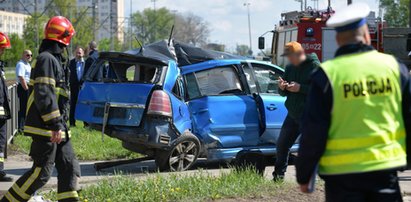 Samochód zaklinowany pomiędzy tramwajem a słupem. W środku ciężarna kobieta i dziecko