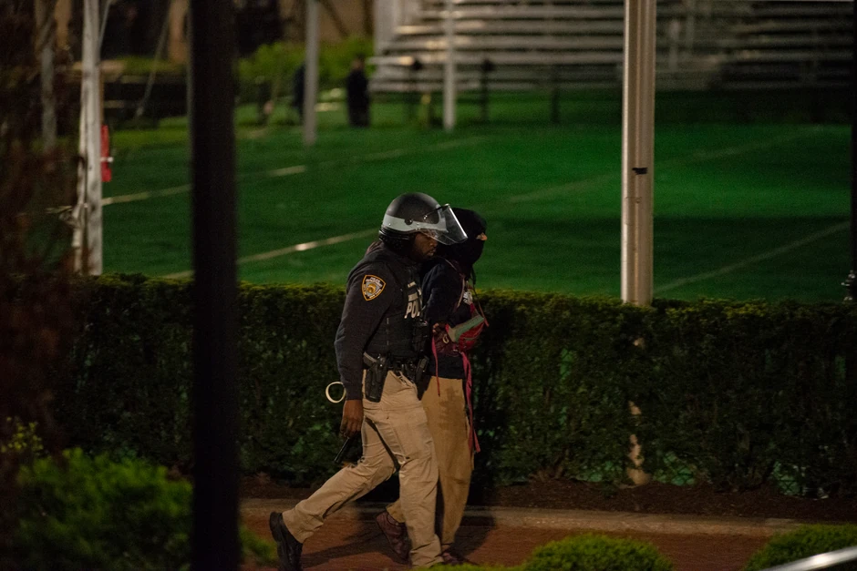 Policajac odvodi jednog od privedenih demonstranata
