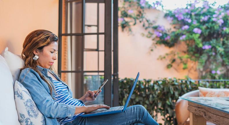 woman using laptop and cell phone at home