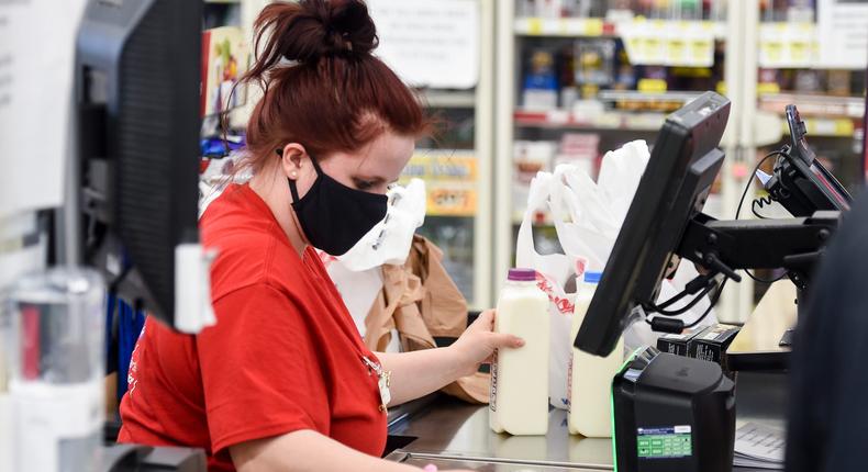 A grocery store cashier scans a customer's groceries. Service and retail workers have seen steadily declining mental health during the pandemic.
