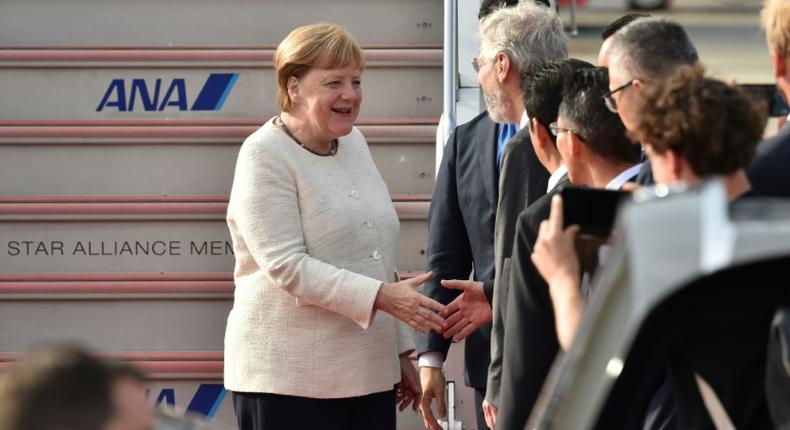 Germany's Chancellor Angela Merkel (L) is greeted by well-wishers upon her arrival in Japan for the G20 summit as officials sought to play down fears over her health