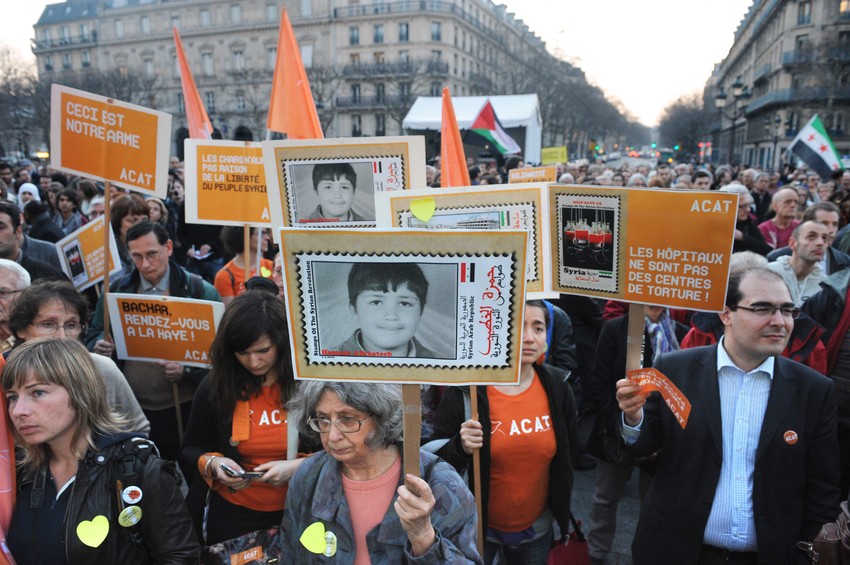 Demonstranti drže sliku Hamze al Katiba tokom antirežimskih protesta 2012. u Siriji
