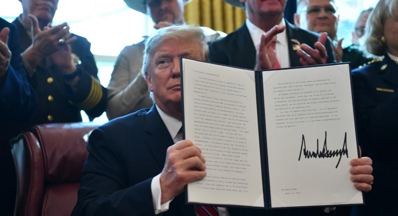 US President Donald Trump displays his veto, which overrides congressional opposition to his declaration of a national emergency at the Mexican border