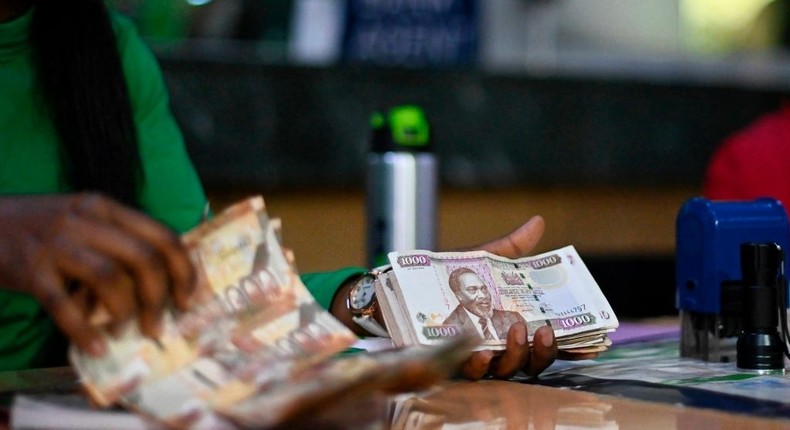 A bank clerk cheking old-issue currency bills received from a client to exchange for new-issue tender at a branch of a local bank in the Kenyan capital, Nairobi, September 30, 2019. - Kenya demonetized it's old-series tender at midnight tonight in favour of new currency notes, a move intended to curb laundering of money acquired through corruption, especially in government accounting, that is rampant in the East African nation.  (Photo by TONY KARUMBA/AFP via Getty Images)