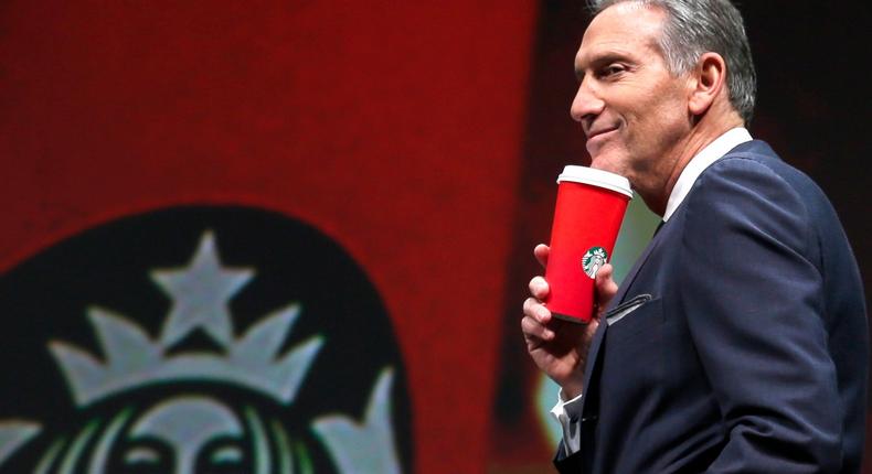 Starbucks CEO Howard Schultz holds one of the company's red holiday cups as he speaks at the coffee company's 2016 shareholders meeting in Seattle.