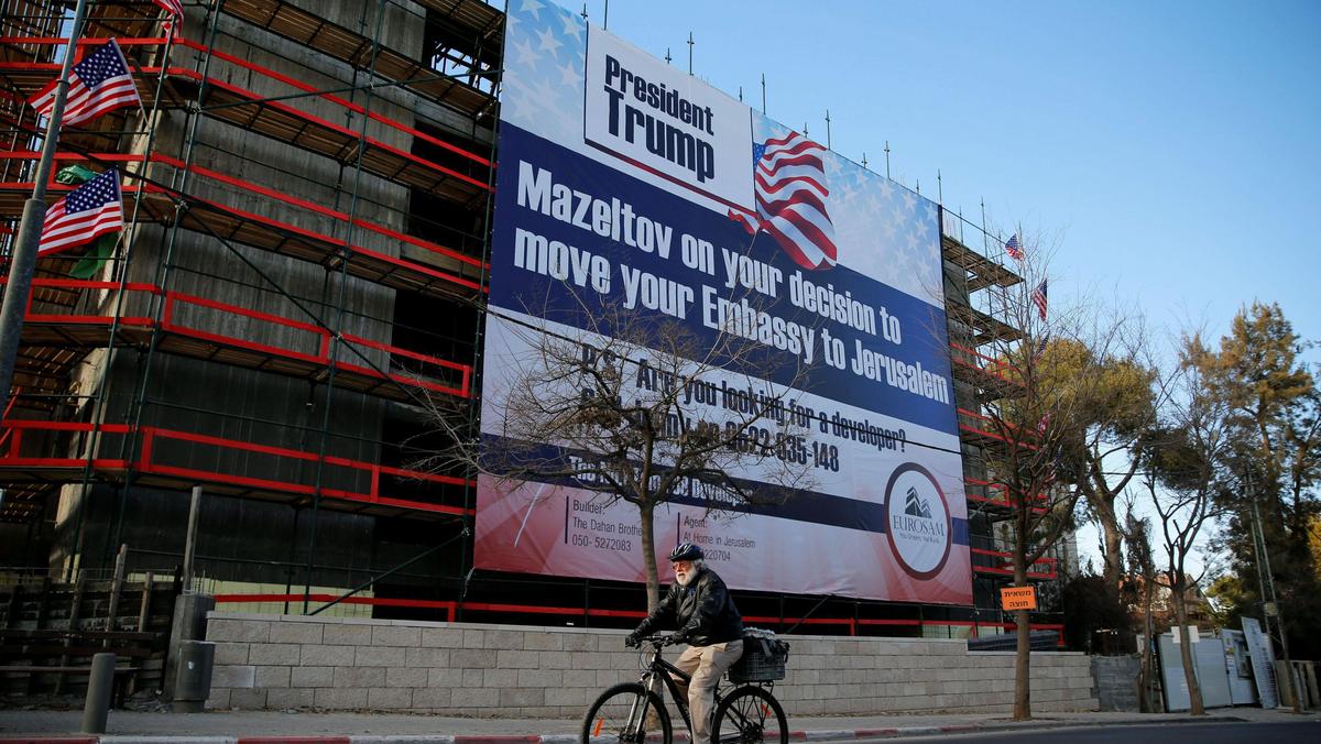 People walk past a giant banner on a building congratulating U.S. President-elect Donald Trump in Je