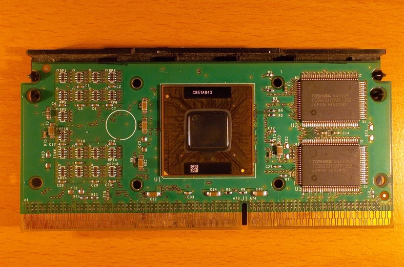 Pentium II w wersji do złącza Slot 1. Pamięć podręczną (cache) tworzą dwie kości, widoczne po prawej stronie. W tamtych czasach produkowała je Toshiba