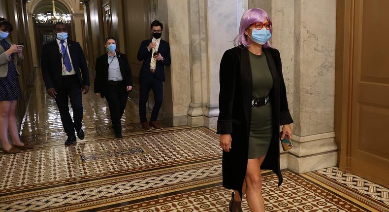 Senator Kyrsten Sinema walks down a hall of the US Capitol.
