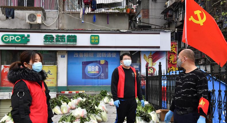 Volunteers wearing face masks stand next to vegetables to be delivered to residents of a residential area in Wuhan, the epicentre of the novel coronavirus outbreak, Hubei province, China March 5, 2020.  REUTERS/Stringer