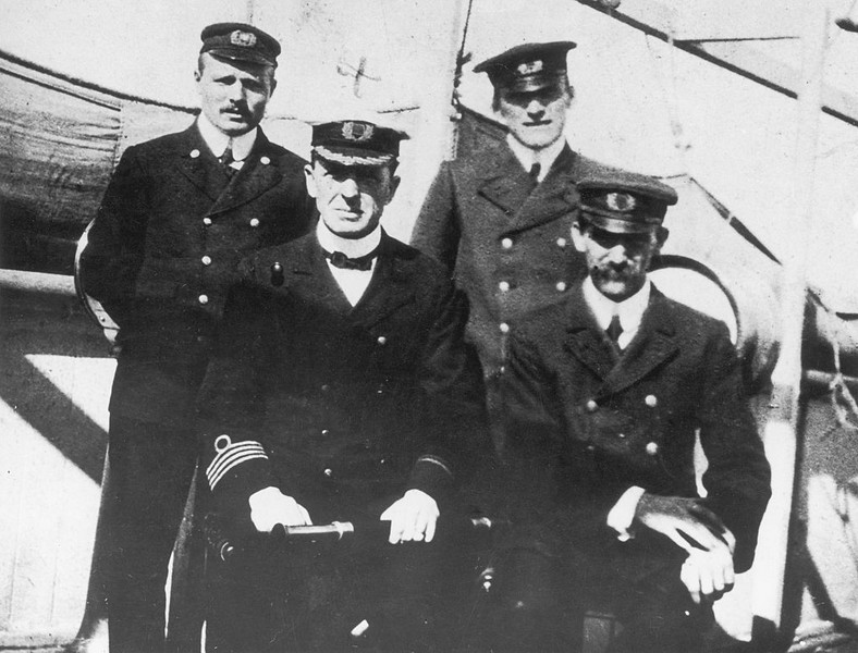 Kapitan Stanley Lord z SS Californian (w pierwszym rzędzie trzyma lunetę) pozuje z trzema starszymi oficerami