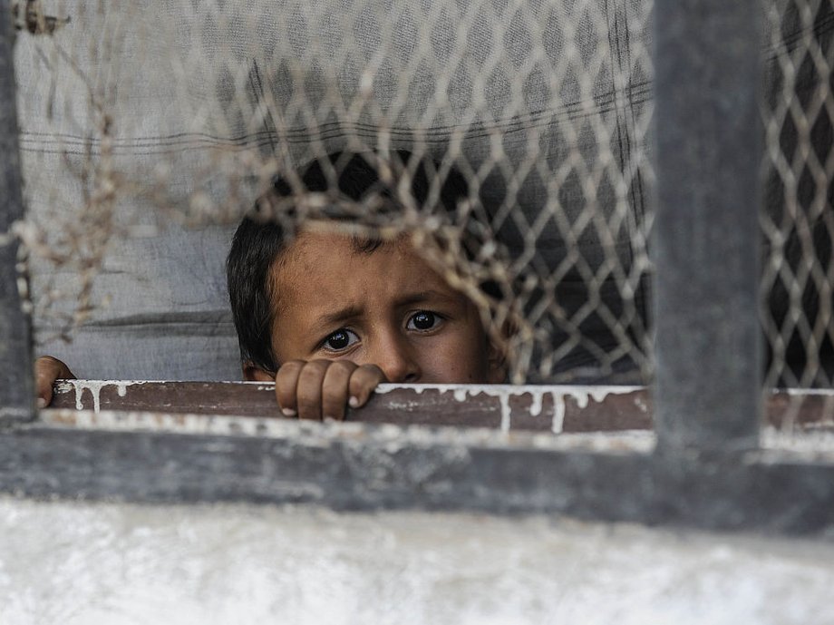 A boy looks out from a window of his home in the border town of Jarablus, August 31, 2016, Syria.