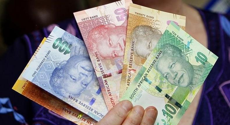 The hand of former South African Reserve Bank Governor Gill Marcus is seen holding South Africa's new rand banknotes - which feature an image of former president Nelson Mandela on the front in a file photo. 