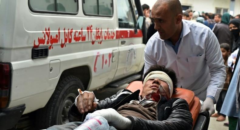 A wounded Afghan man is transferred from an ambulance to hospital after a bombing at a Shiite mosque in Kabul on November 21, 2016