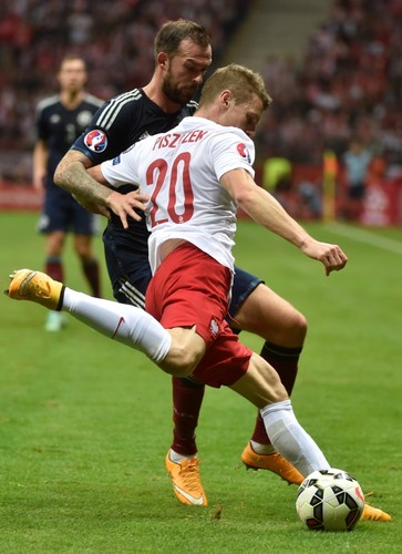 Polak Arkadiusz Milik (L) fetuje z Arturem Jędrzejczykiem (P) strzelenie bramki drużynie Szkocji na 2-2 podczas meczu eliminacyjnego piłkarskich mistrzostw Europy