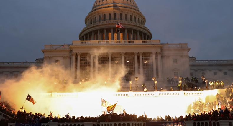 An explosion caused by a police munition is seen while supporters of President Donald Trump gather in front of the US Capitol Building in Washington DC on January 6, 2021.