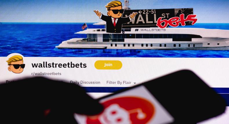 The WallStreetBets page seen in the background of a silhouette hand holding a mobile phone with Reddit logo. Photo Illustration by Rafael Henrique/SOPA Images/LightRocket via Getty Images