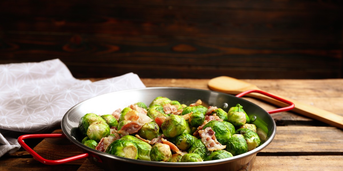 Brussels sprouts vegetable cream soup over marble background, top view