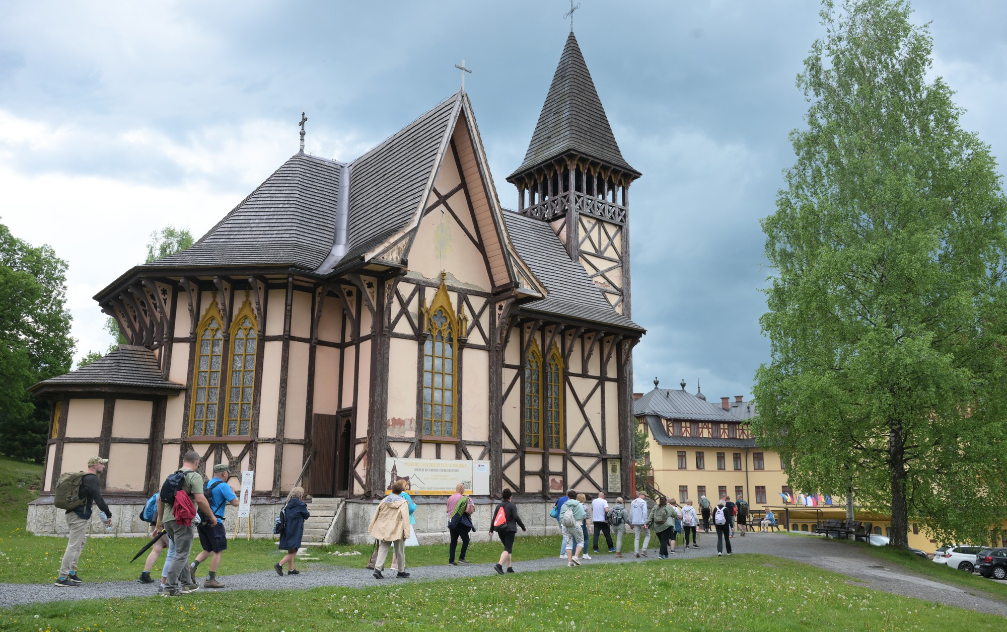 Turisti kráčajú pri Kostole Nepoškvrneného počatia Panny Márie v Starom Smokovci.