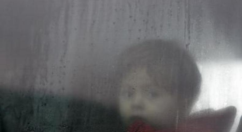 A migrant child sits in a bus on the way to a registration camp in Preshevo, Serbia, October 24, 2015.