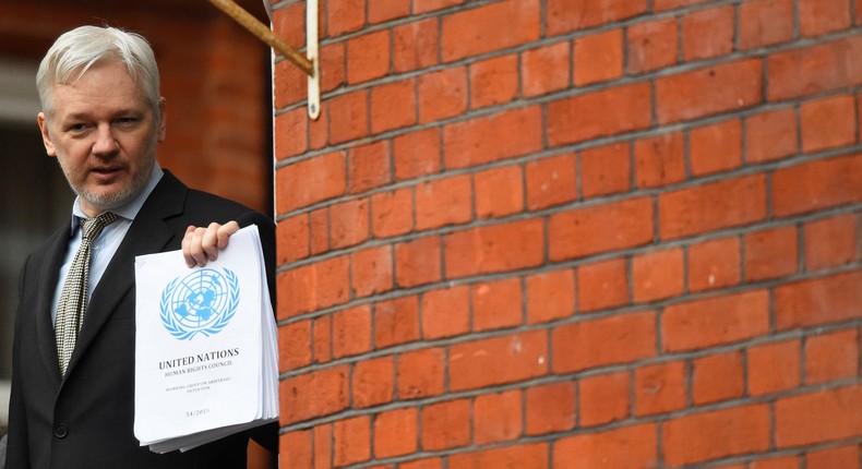 WikiLeaks founder Julian Assange holds a copy of a UN ruling as he makes a speech from the balcony of the Ecuadorian Embassy, in London, February 5, 2016.