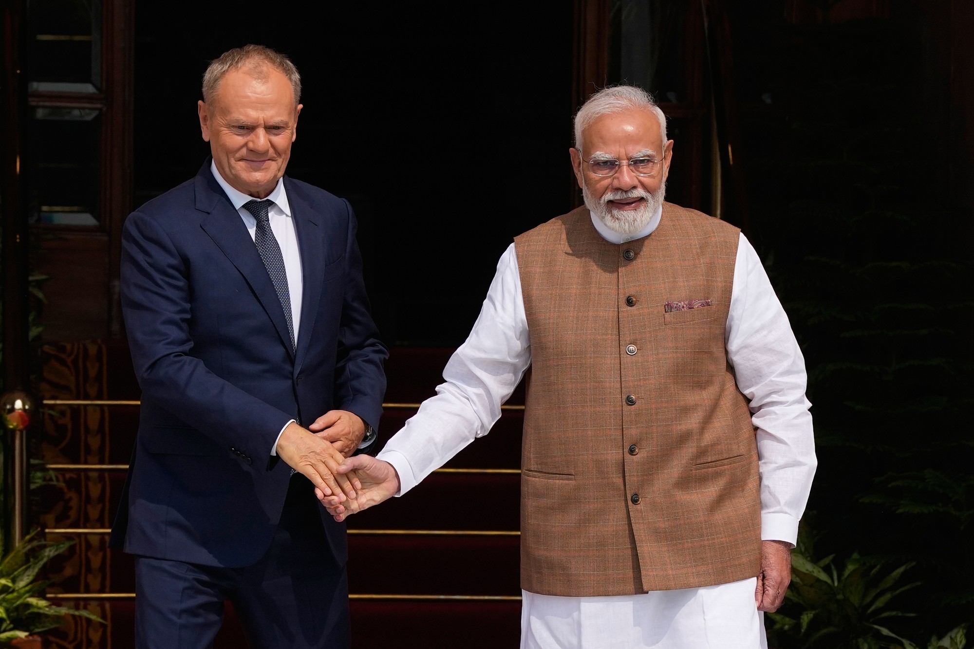 Poľský premiér Donald Tusk si podáva ruku s indickým premiérom Naréndrom Módím.