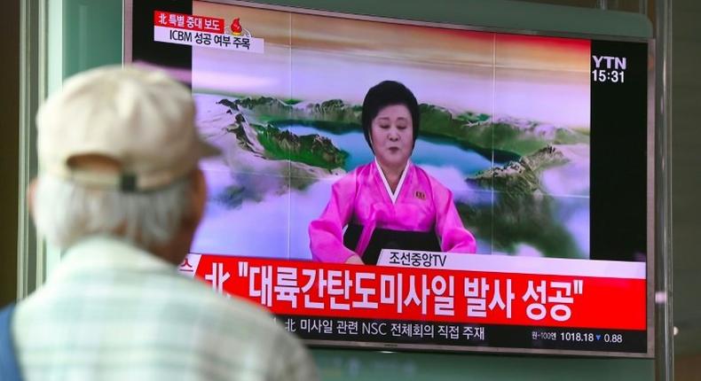 People watch a television news broadcast showing a North Korean announcer reading a statement on the country's new ICBM test, at a railway station in Seoul on July 4, 2017