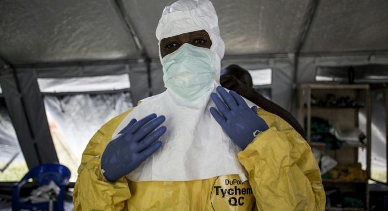 A medical worker puts on his Personal Protective Equipment (PPE) ahead of entering an Ebola Treatment Centre in Beni