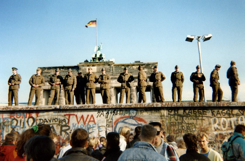 Listopad 1989, mur jeszcze stoi, a na nim żołnierze NRD pilnujący grznicy między Wschodem a Zachodem